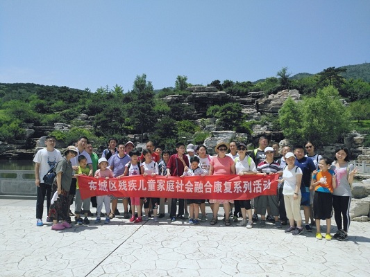 残疾人儿童家庭在公园门口合影