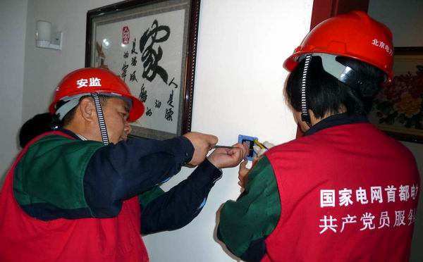 图为党员服务队队员为职康站检修电线插座