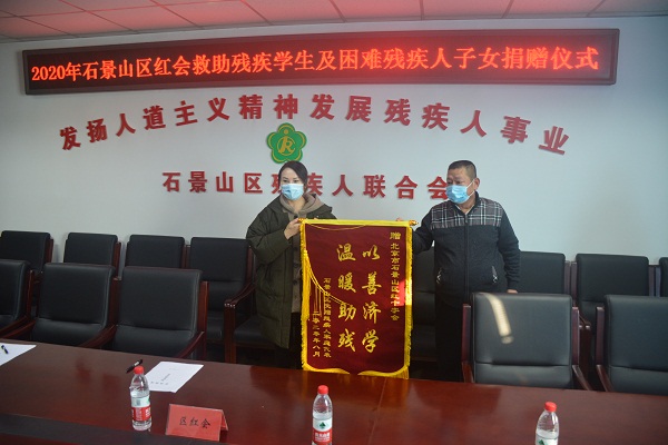 图为残疾人代表向红十字会赠锦旗