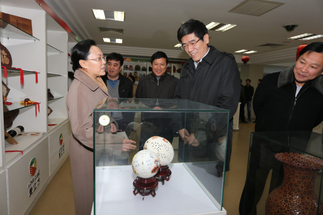 图为中国残联鲁勇理事长欣赏残疾人艺术品