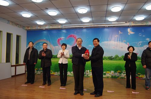 图为市残疾人福利基金会理事长梁田向中国福利基金会赠送了荣誉瓷瓶