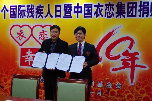 图片为：市残疾人福利基金会理事长梁田代表与衣恋公司代表签订捐赠协议