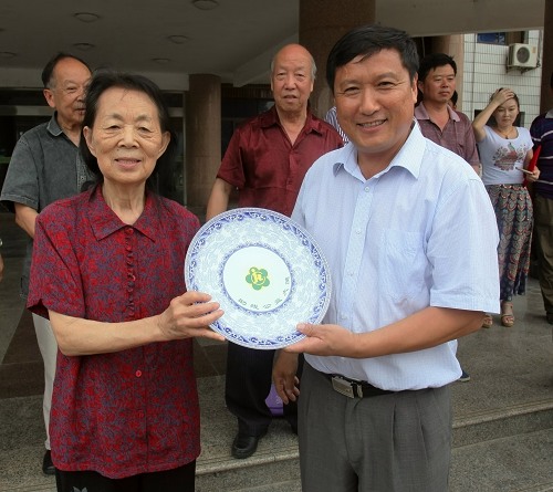 图片为：梁田理事长向爱心人士颁发爱心大使荣誉瓷盘