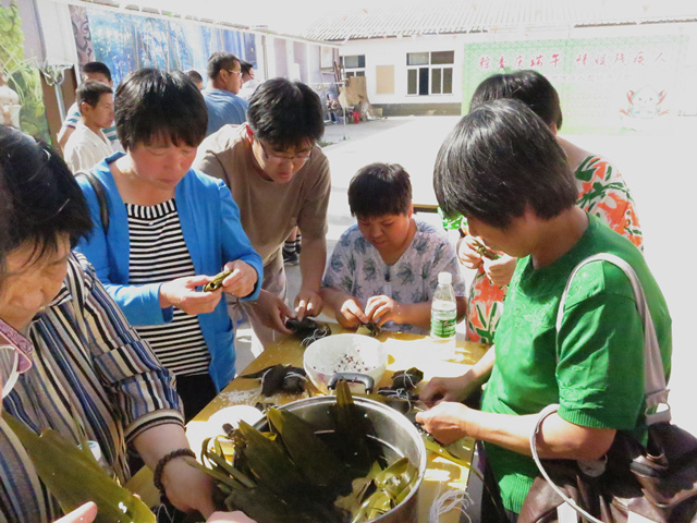 图为残疾人包粽子现场