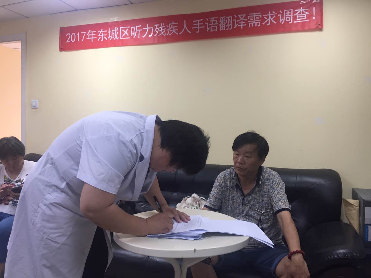 听力测试老师正在对听力残疾人进行问卷调查