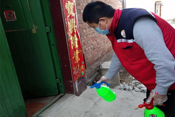 图为温馨家园帮助困难残疾人家庭进行消毒